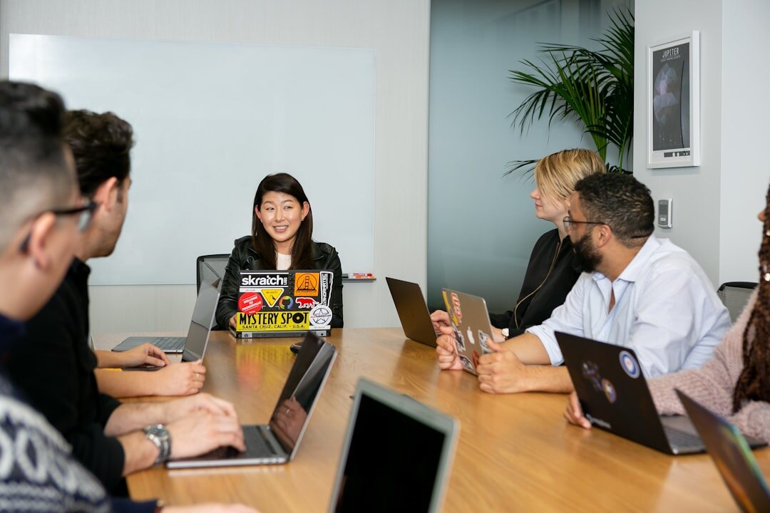 Editorial team meeting around a table with laptops